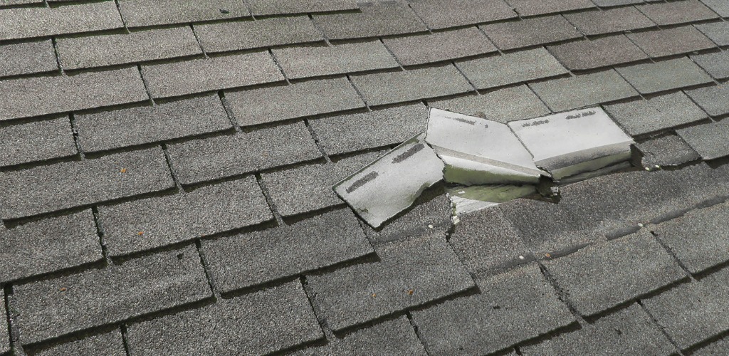 punctured grey architectural shingles on a roof