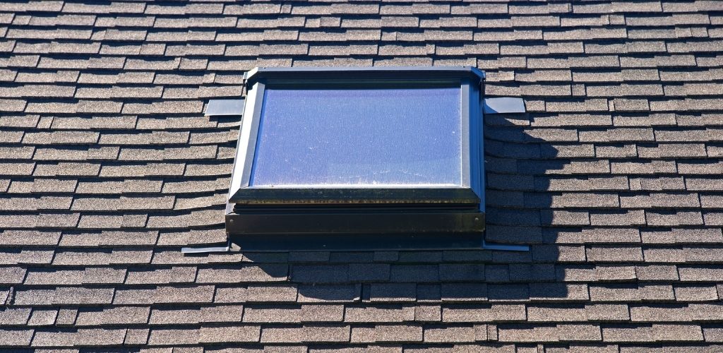 rectangular skylight installed on a brown asphalt shingled roof